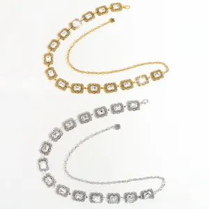 Détail d'une chaîne de taille vintage en métal avec strass et pendentifs fleuris