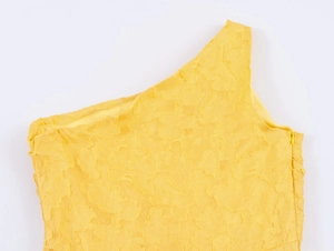 Detailed macro shot of yellow jacquard fabric and hidden side zipper on ruffle dress