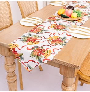 Christmas table runner with festive bell and pinecone print featuring scalloped wave edges