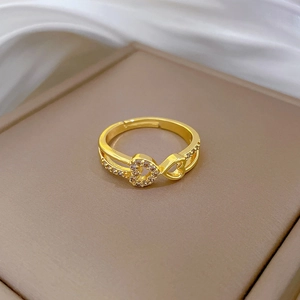 Detailed macro of gold heart and infinity ring with crystal accents on a jewelry box
