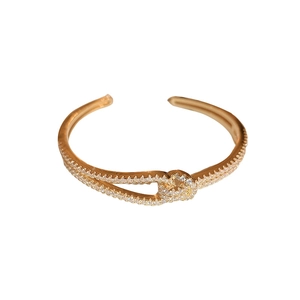Elegante goudvergulde open armband met fonkelende zirkonia stenen in een kruisontwerp
