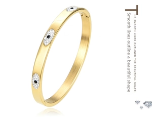 Detail of a gold-tone evil eye bangle with sparkling crystals and side hinge closure