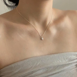 Minimalist 925 sterling silver starburst necklace with zircon on a female neck