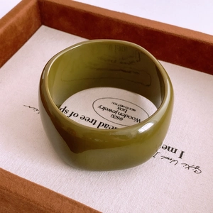 Détail d'un bracelet jonc épais en résine acrylique vert olive avec une finition polie