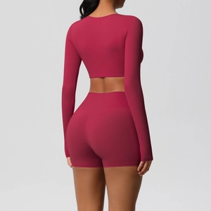 Rear view of tight yoga set showing berry red long sleeve crop top and biker shorts