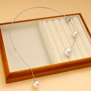 Detailansicht eines silbernen Chokers mit weißen Perlen und Metallkugeln auf Schmucktablett