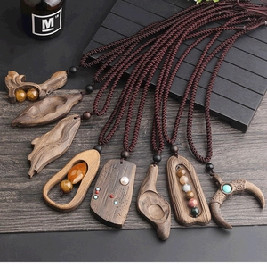 Detailed view of handmade ethnic wooden pendant necklace with brown braided cord