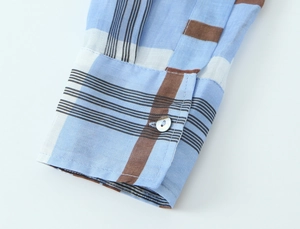 Detailed macro view of blue and brown checkered shirt cuffs with high-quality buttons