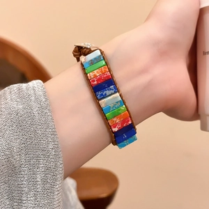 Détail d'un bracelet en cuir tissé main avec des perles carrées en pierre naturelle au poignet
