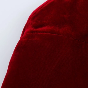 Vue détaillée de la texture du tissu en velours rouge et des finitions de couture