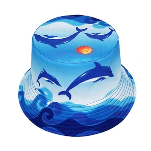 Outdoor sun bucket hat featuring blue dolphin print and wave patterns on a white base