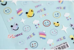 Macro shot of 5D nail art stickers with rainbow smiley faces and Have a Nice Day text