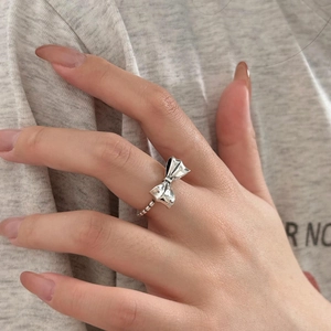 Close-up of 925 sterling silver bow ring with beaded band on model hand