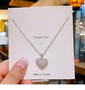 Close-up of heart-shaped pendant with micropave cubic zirconia and silver titanium chain