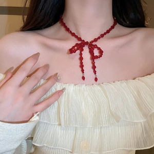 Gros plan d'une boucle d'oreille vintage à nœud en perles de cristal rouge