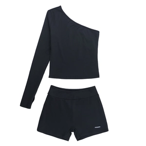 Flat lay of black two-piece sports set with single-shoulder top and tight shorts