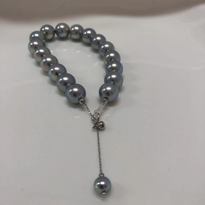 Macro detail of dark grey pearl bracelet with S925 silver clasp on white backdrop