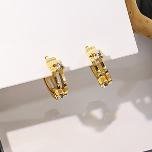 Gros plan de boucles d'oreilles huggie dorées avec double rangée de cristaux brillants