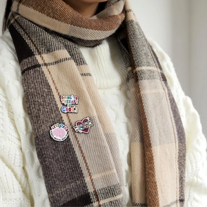 Set of 3 mental health enamel pins on a knitted sweater and beige plaid scarf background