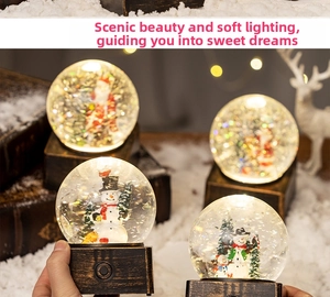 Close-up of a Christmas snow globe with Santa Claus and a warm glowing light base