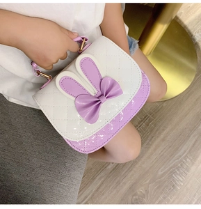 Detailed view of the white and purple quilted handbag with cute rabbit ears and bow decoration