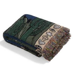 Detail of bohemian woven blanket featuring cactus patterns and colorful fringe edges