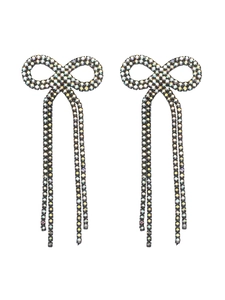 Detail of long bow tassel earrings with shiny rhinestones on a polished copper base