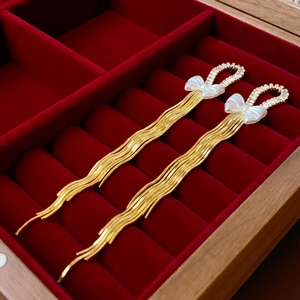 Elegant gold bow earrings with long snake chain tassels and zircon details