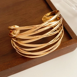 Detailed view of wide gold multi-layer crisscross cuff bracelet with high polish finish