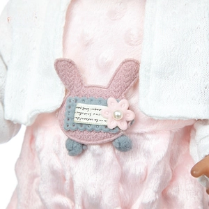 Detail view of pink plush doll romper with white knit cardigan and cute rabbit patch