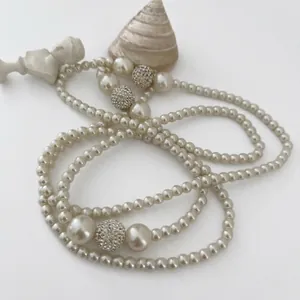 Elegant multi-layered pearl necklace featuring sparkling pave crystal balls and large pearls