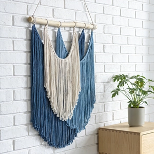 Bohemian hand-woven wall tapestry with colorful cotton tassels on a natural wood pole