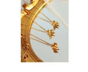 Detail of three elephant pendant necklaces in 18K gold plated finish on mirror
