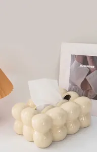 Close-up of cream ceramic tissue box with a bubble cloud design and polished finish