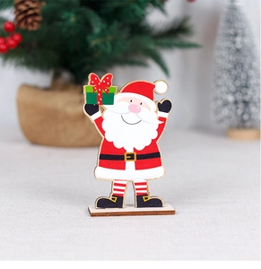 Close-up of wooden Santa ornament with gift box on a festive table setting