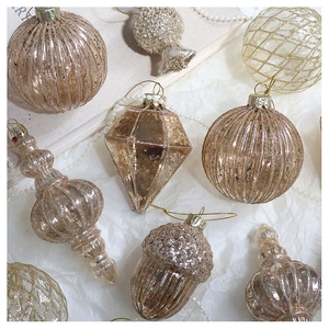 Detailed view of champagne gold Christmas ornaments with glitter and embossed textures