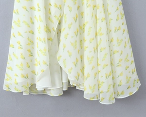 Dettaglio dell'orlo dell'abito in chiffon floreale con fiori gialli e fodera bianca