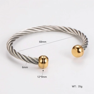 Close-up detail of two-tone cable twist bangle showing 6mm width and 68mm diameter dimensions
