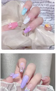 Detail of macaron press-on nails with 3D resin bows and translucent heart charms
