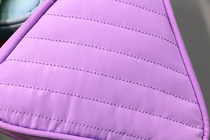 Close-up of quilted purple fabric with detailed horizontal stitching and soft texture