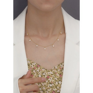 Close-up of gold s925 silver necklace featuring rectangular zircon stones on a model