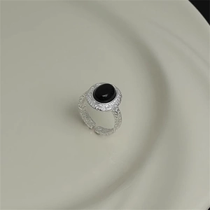 Close-up of vintage S925 silver ring with black oval gemstone and engraved texture