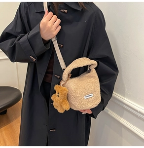 Détail du sac seau beige en polaire avec étiquette Clear K et breloque ours en peluche