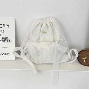 Detail view of a white lace floral drawstring backpack with elegant ribbon straps