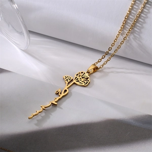 Close-up of gold stainless steel necklace with Arabic script and hollow flower pendant