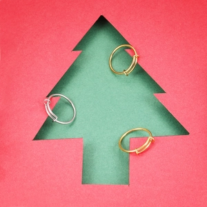 Drie minimalistische verstelbare ringen in goud en zilver tegen een kerstachtergrond