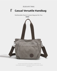 Detail view of grey canvas tote bag with brown handles and adjustable shoulder strap