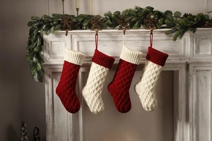 Set mit 4 rot-elfenbeinfarbenen gestrickten Weihnachtssocken mit Rautenmuster am Kamin