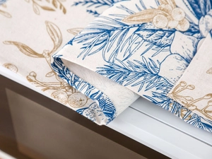 Close-up of cotton linen fabric texture with blue and gold pine botanical prints