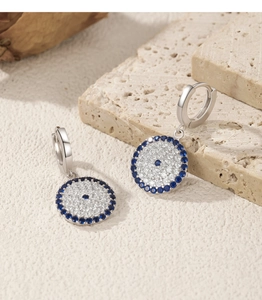 Close-up of S925 silver evil eye hoop earrings on stone with blue crystal accents